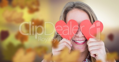Woman's face in forest with leaves and love hearts over eyes