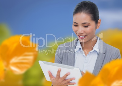 Woman using tablet with leaves