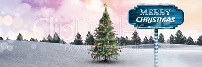 Merry Christmas text on Wooden signpost in Christmas Winter landscape with Christmas tree