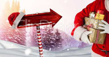 Santa holding gifts and Wooden signpost in Christmas Winter landscape and Santa hat