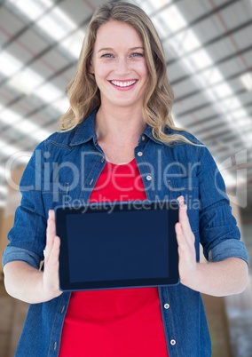 Woman holding tablet with warehouse background