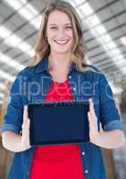 Woman holding tablet with warehouse background