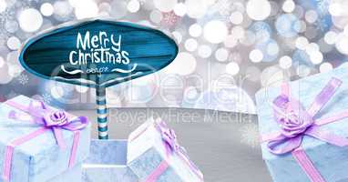 Merry Christmas text and gifts with Wooden signpost in Christmas Winter landscape