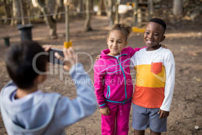 Boy taking picture of his friends with mobile phone