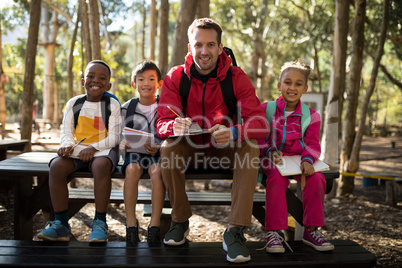 Portrait of teacher assisting kids in studying