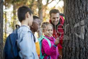Teacher and kids examining tree trunk