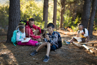 Teacher and kids relaxing in forest