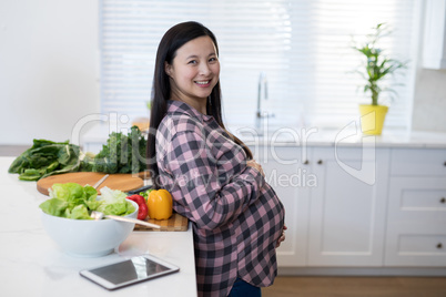 Portrait of pregnant woman touching her stomach