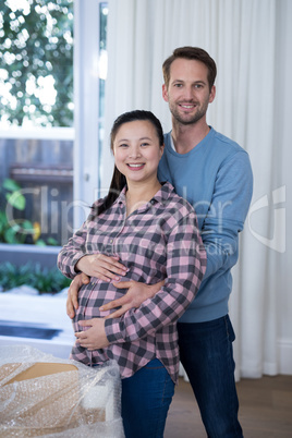 Man touching womans pregnant belly at new house