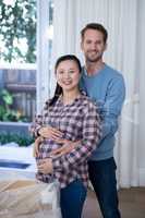 Man touching womans pregnant belly at new house