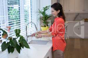 Woman washing fruit in kitchen