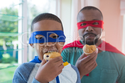 Father and son having muffin at home