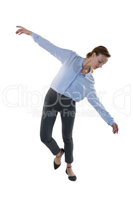 Female executive balancing while waking against white background