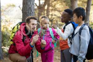 Teacher and kids examining plant