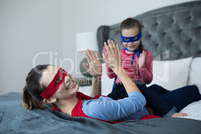 Mother and daughter having fun in bedroom