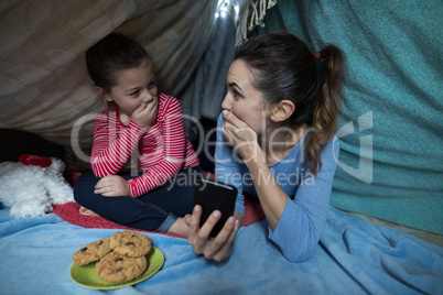 Shocked mother and daughter looking at each other