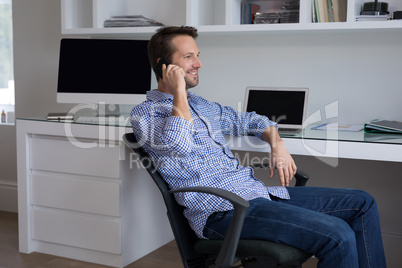 Man talking on mobile phone at desk