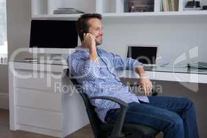 Man talking on mobile phone at desk