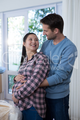 Man touching womans pregnant belly at new house