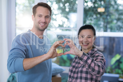 Smiling couple making heart shape with hands