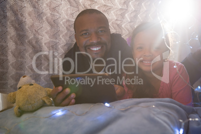 Father and daughter using digital tablet in bedroom Father and daughter using digital tablet in bedroom