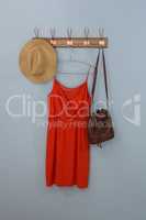 Red dress, hat and bag hanging on hook
