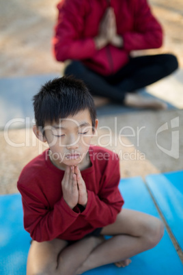 Overhead of boy meditating in park