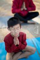 Overhead of boy meditating in park