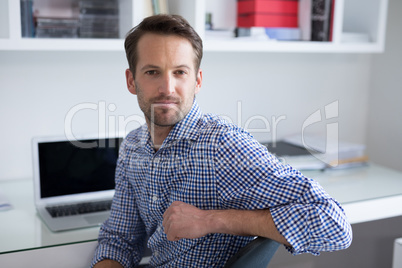 Confident man sitting on chair at home