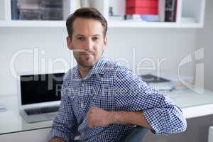 Confident man sitting on chair at home