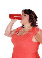 Plus-sized woman drinking from red mug