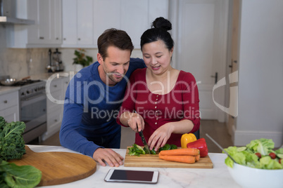 Couple chopping vegetables in the kitchen