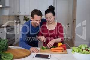 Couple chopping vegetables in the kitchen