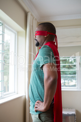 Man in superhero costume looking through window