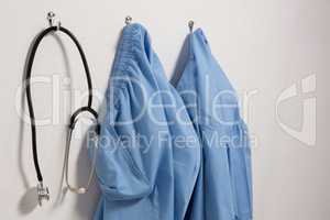 Scrubs and stethoscope hanging on hook