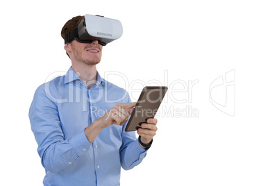 Male executive using virtual reality headset and digital tablet