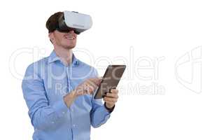 Male executive using virtual reality headset and digital tablet