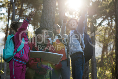 Kids pointing at distance in forest