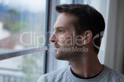 Thoughtful man looking through window