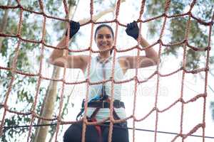 Portrait of beautiful woman climbing net