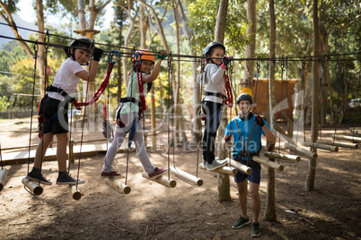 Kids walking on rope bridge in park