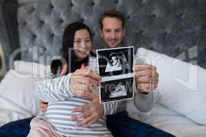 Man and pregnant woman looking at sonography