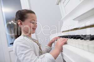 Close-up of cute girl playing piano