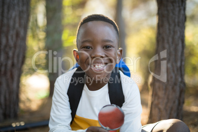 Portrait of happy boy holding magnifying glass