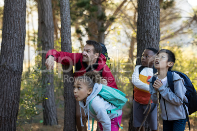 Teacher pointing at distant in forest