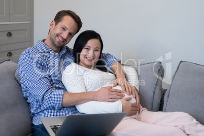 Happy couple feeling the presence of baby in stomach