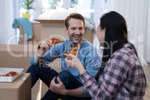 Couple having pizza at their new home