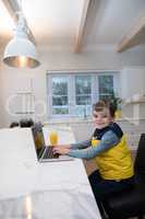 Boy using laptop in kitchen