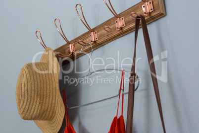 Straw hat, dress and bag hanging on wall