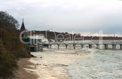 a storm at sea, the waves cover the pier